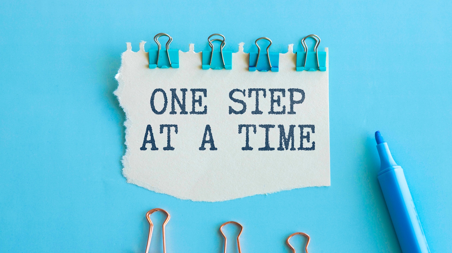 One Step at a Time Motivational Quote on Torn Paper